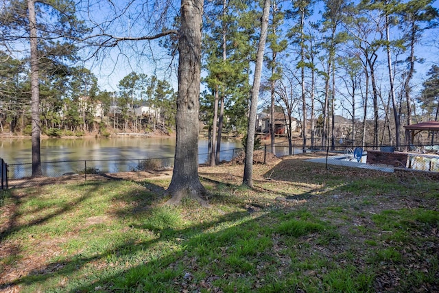 view of yard featuring a water view and fence