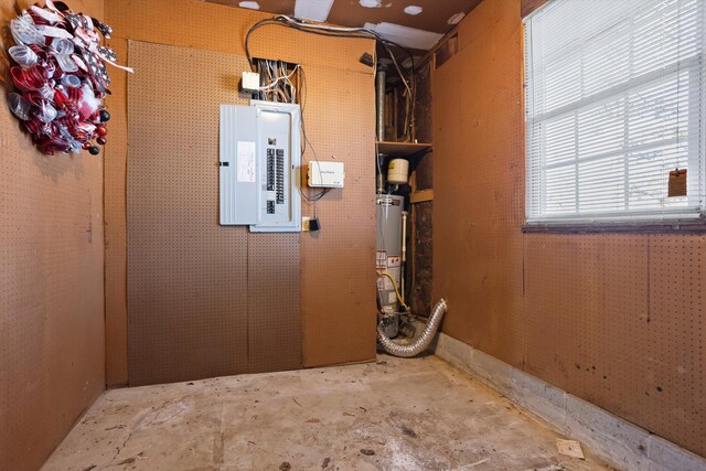 utility room featuring electric panel and water heater