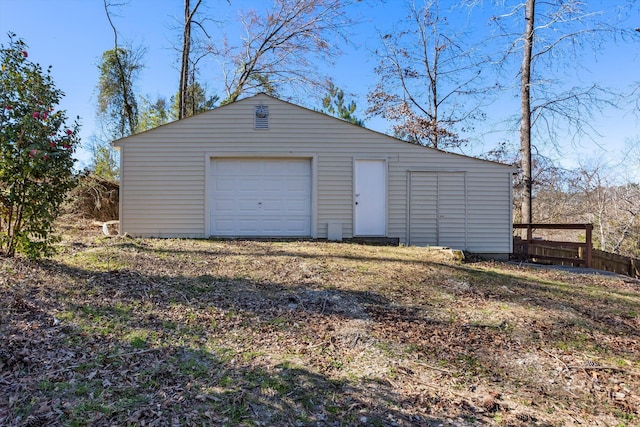 detached garage with fence and driveway