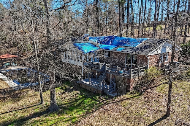 back of house with brick siding, stairway, and a wooden deck