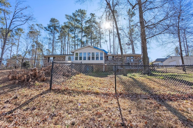 back of property with stone siding, fence private yard, and a sunroom