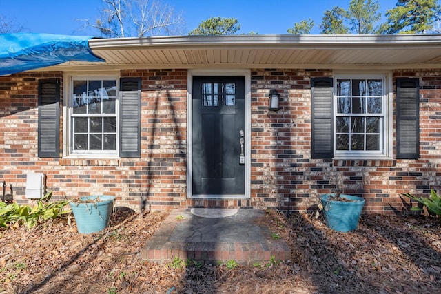 property entrance featuring brick siding