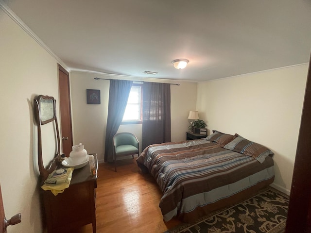 bedroom with wood-type flooring and crown molding