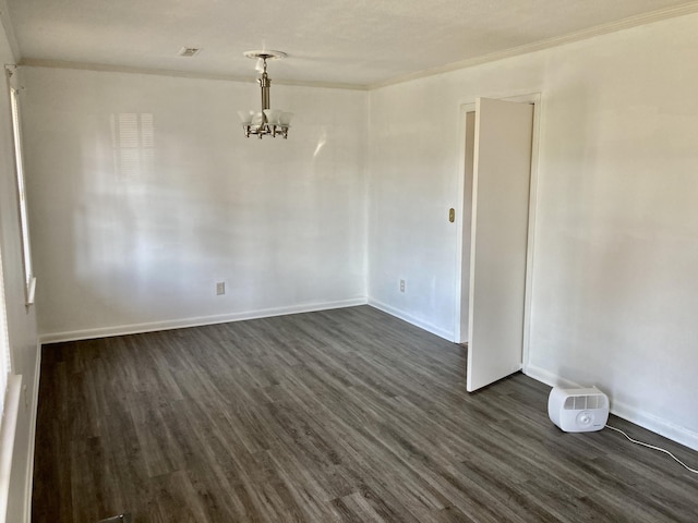 unfurnished room featuring an inviting chandelier, dark hardwood / wood-style floors, and ornamental molding