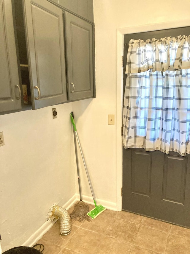 interior space featuring light tile patterned flooring, cabinets, and electric dryer hookup