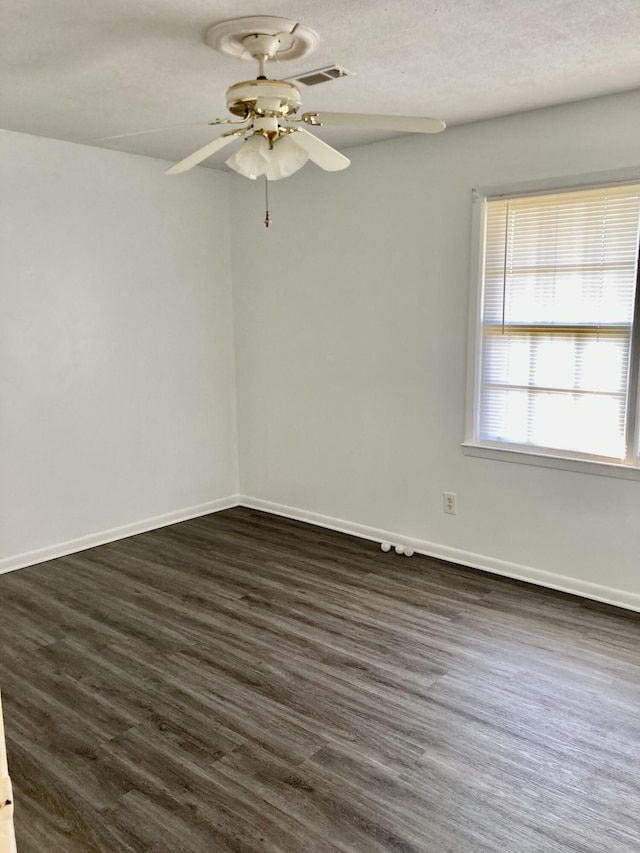 spare room featuring a textured ceiling, dark wood-type flooring, and ceiling fan