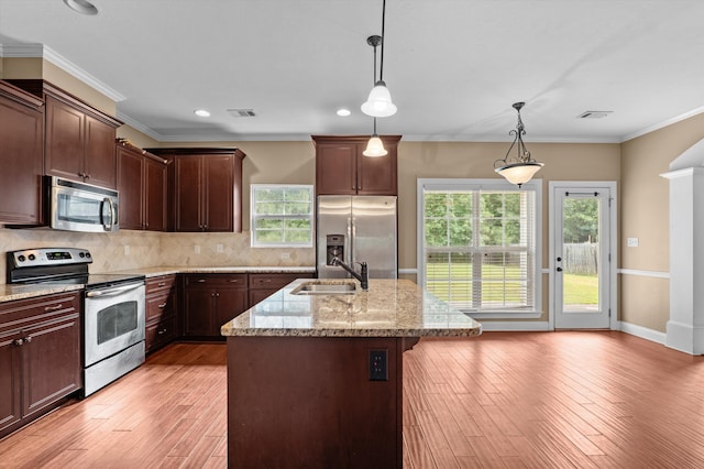 436 Sebastian Dr, Grovetown, GA 30813 - kitchen with appliances with stainless steel finishes, light wood-type flooring, light stone counters, a center island with sink, and decorative light fixtures