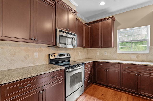 436 Sebastian Dr, Grovetown, GA 30813 - kitchen featuring appliances with stainless steel finishes, light wood finished floors, ornamental molding, light stone counters, and backsplash