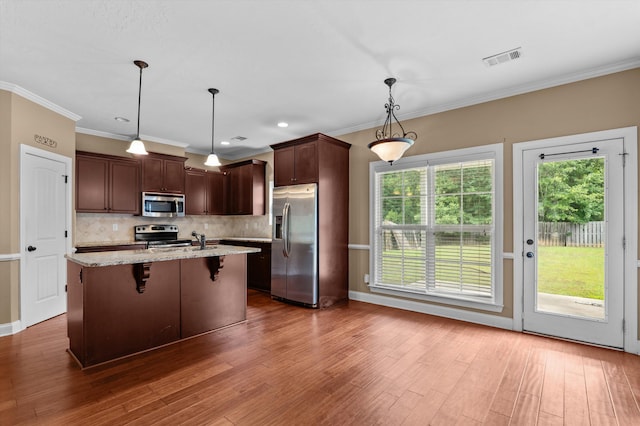436 Sebastian Dr, Grovetown, GA 30813 - kitchen with stainless steel appliances, tasteful backsplash, wood finished floors, a center island with sink, and light stone counters