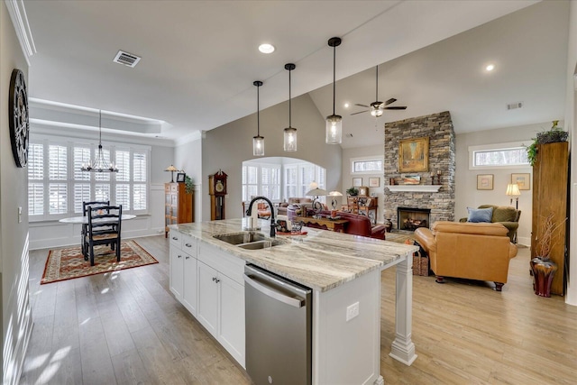 kitchen with visible vents, light wood-type flooring, a sink, a fireplace, and dishwasher