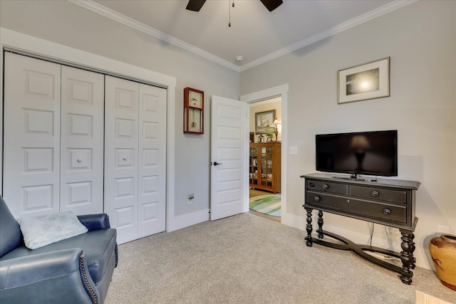 living area with baseboards, a ceiling fan, carpet flooring, and crown molding