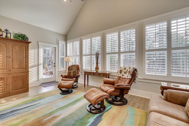 sitting room with baseboards, lofted ceiling, and light wood finished floors