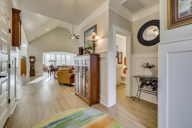 hallway featuring crown molding, light wood-style flooring, and visible vents