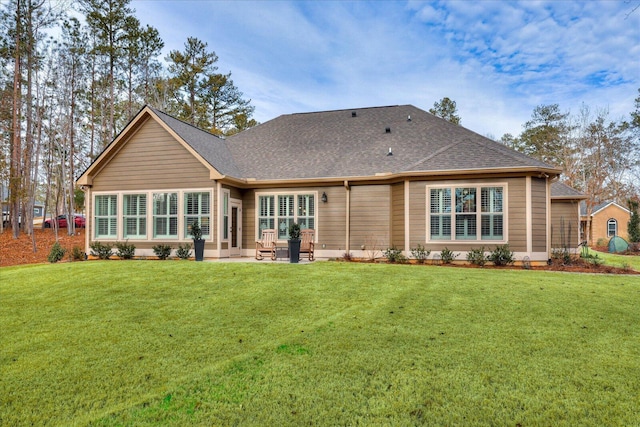 back of house featuring a yard, a patio area, and a shingled roof