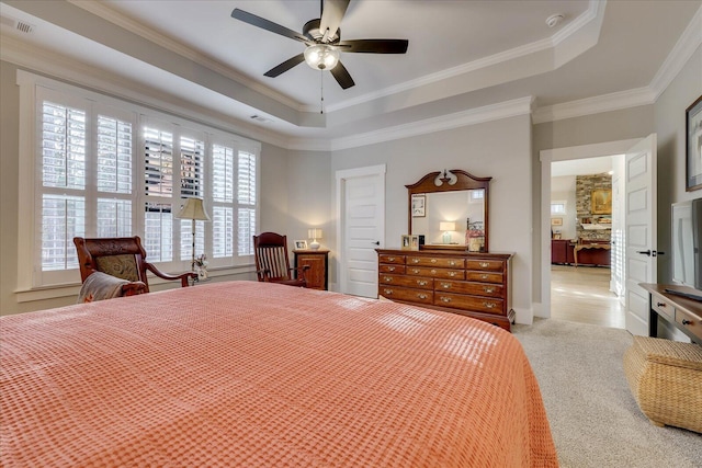 bedroom featuring ceiling fan, a tray ceiling, visible vents, and ornamental molding