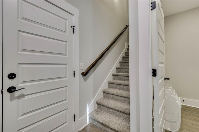 staircase with baseboards and wood finished floors