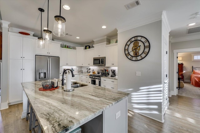 kitchen with a sink, stainless steel appliances, visible vents, and crown molding