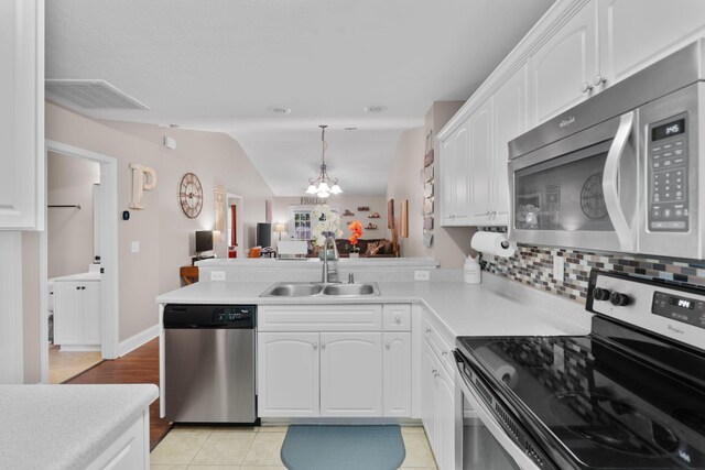 123 Winnipeg Rd, North Augusta, SC 29841 - kitchen featuring stainless steel appliances, a sink, a peninsula, white cabinetry, and a chandelier