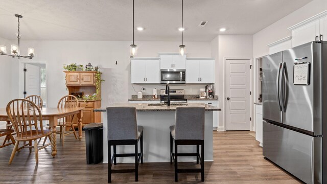 4756 Storey Mill Rd, Hephzibah, GA 30815 - kitchen with appliances with stainless steel finishes, a sink, wood finished floors, a chandelier, and a kitchen island with sink