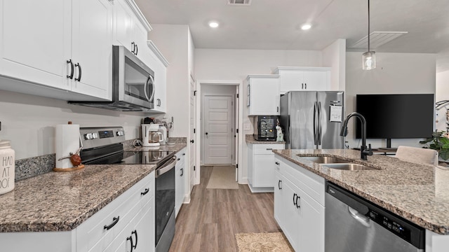 4756 Storey Mill Rd, Hephzibah, GA 30815 - kitchen featuring appliances with stainless steel finishes, a sink, light wood-style floors, light stone countertops, and white cabinetry