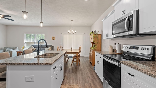 4756 Storey Mill Rd, Hephzibah, GA 30815 - kitchen with stainless steel appliances, a sink, wood finished floors, an island with sink, and light stone counters