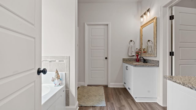 4756 Storey Mill Rd, Hephzibah, GA 30815 - bathroom with vanity, wood finished floors, and a garden tub