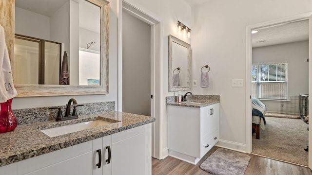 4756 Storey Mill Rd, Hephzibah, GA 30815 - ensuite bathroom with wood finished floors, two vanities, baseboards, and a shower with door