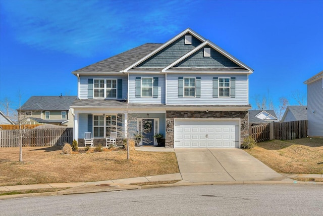 craftsman-style house featuring covered porch, concrete driveway, an attached garage, and fence