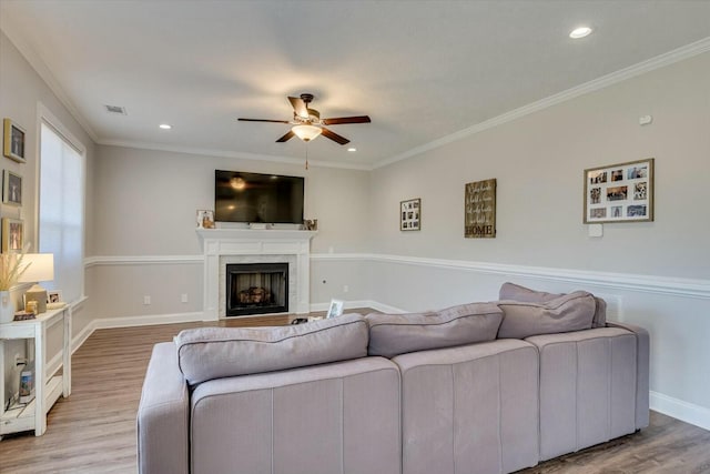 living area featuring light wood-type flooring and ornamental molding