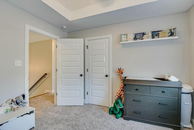 recreation room with baseboards and light carpet