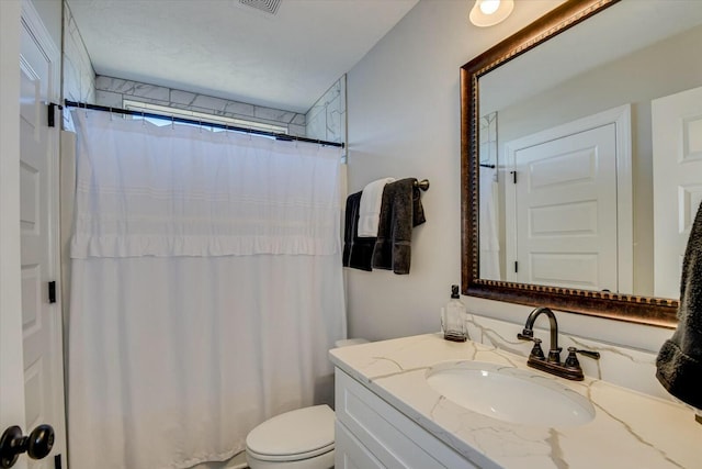 bathroom with a shower with shower curtain, toilet, vanity, and visible vents