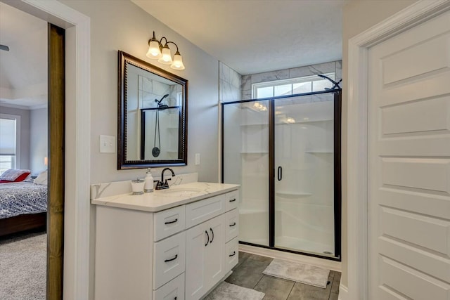 ensuite bathroom with plenty of natural light, vanity, and a shower stall