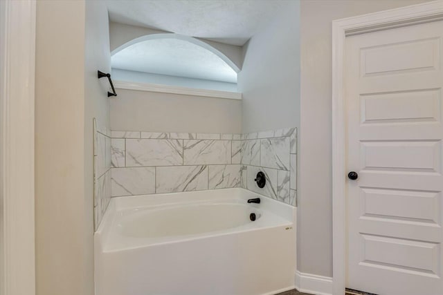 full bathroom with baseboards and a bath