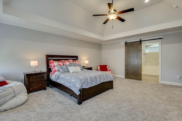 carpeted bedroom featuring baseboards, a raised ceiling, a barn door, and vaulted ceiling