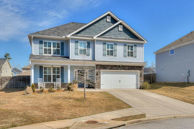 craftsman-style home with stone siding, a porch, an attached garage, and fence