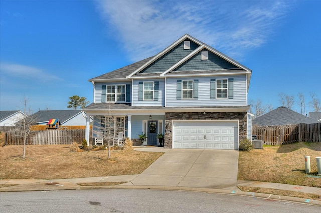 craftsman house featuring concrete driveway, central air condition unit, fence, and stone siding