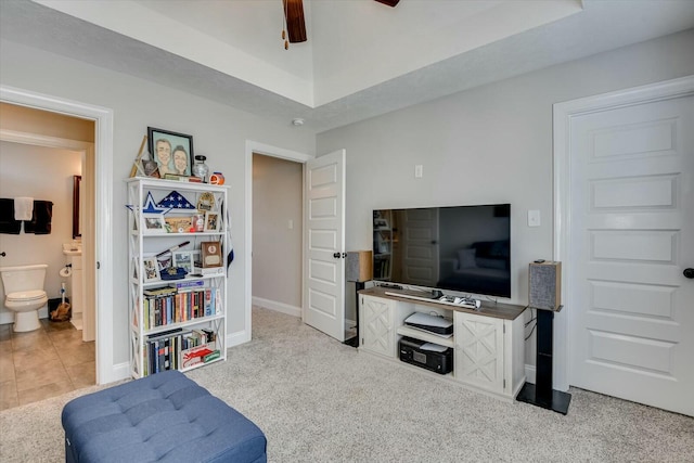 carpeted living room featuring baseboards, ceiling fan, and tile patterned flooring