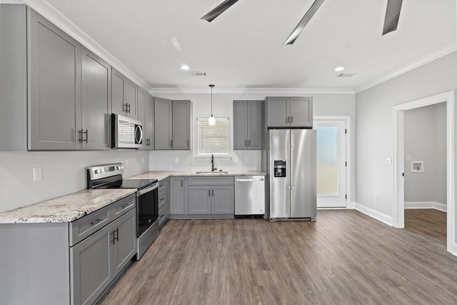 kitchen with appliances with stainless steel finishes, decorative light fixtures, gray cabinets, and sink