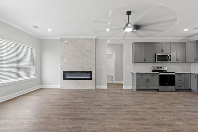 kitchen featuring a fireplace, appliances with stainless steel finishes, ceiling fan, and gray cabinetry