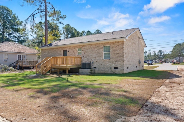 back of property with a yard, central AC unit, and a deck