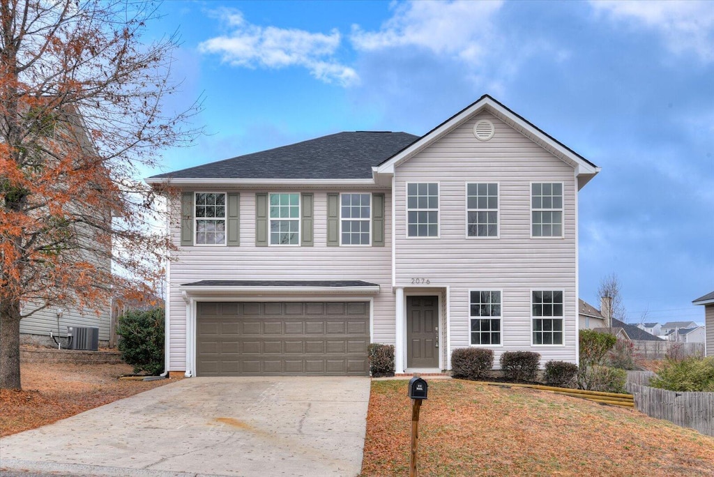 view of front of home with central AC unit and a garage