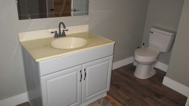 bathroom with hardwood / wood-style floors, vanity, and toilet