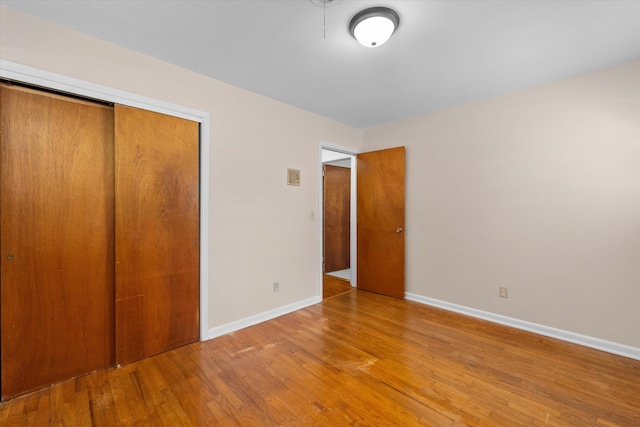 unfurnished bedroom featuring hardwood / wood-style floors and a closet