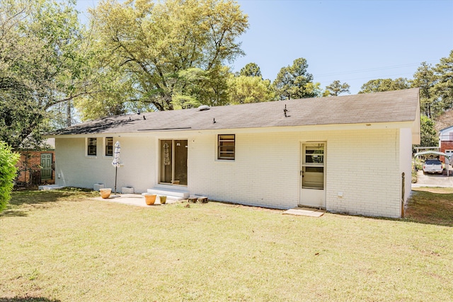 rear view of property featuring a lawn