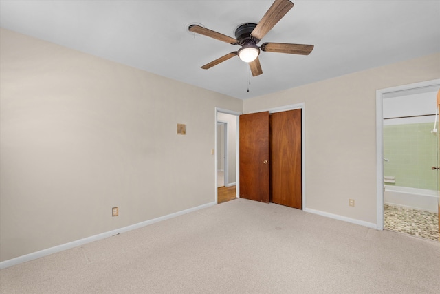 unfurnished bedroom featuring ensuite bathroom, a closet, ceiling fan, and light carpet