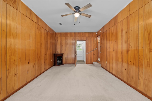 living room with light carpet, ceiling fan, and wood walls