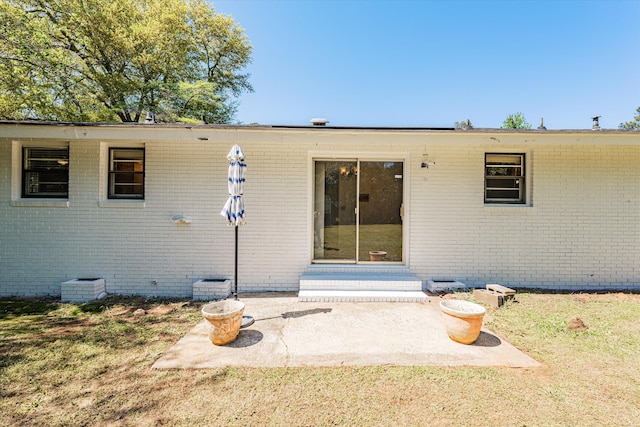 back of property with a yard and a patio