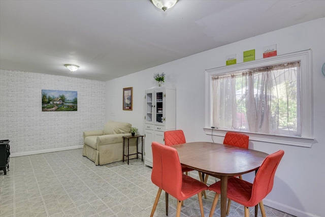 dining space featuring brick wall