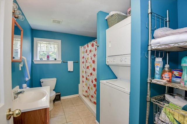 laundry area featuring stacked washer / drying machine, light tile patterned flooring, and sink