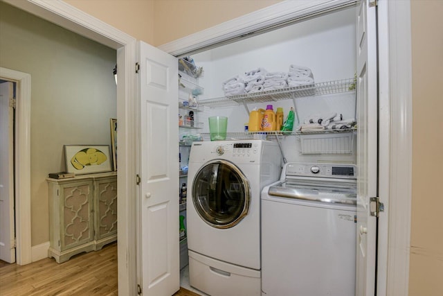 laundry room with independent washer and dryer and light wood-type flooring